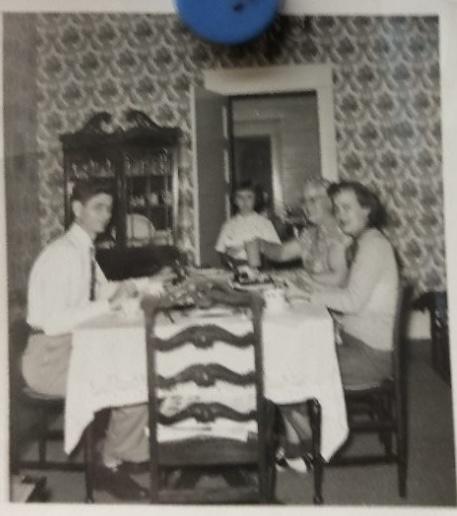 View of the dining room. Behind Judy is a swinging door into the kitchen. At the table are my grandmother, her younger sister, Mary, and her husband, Zeno Brown Teel, Jr.